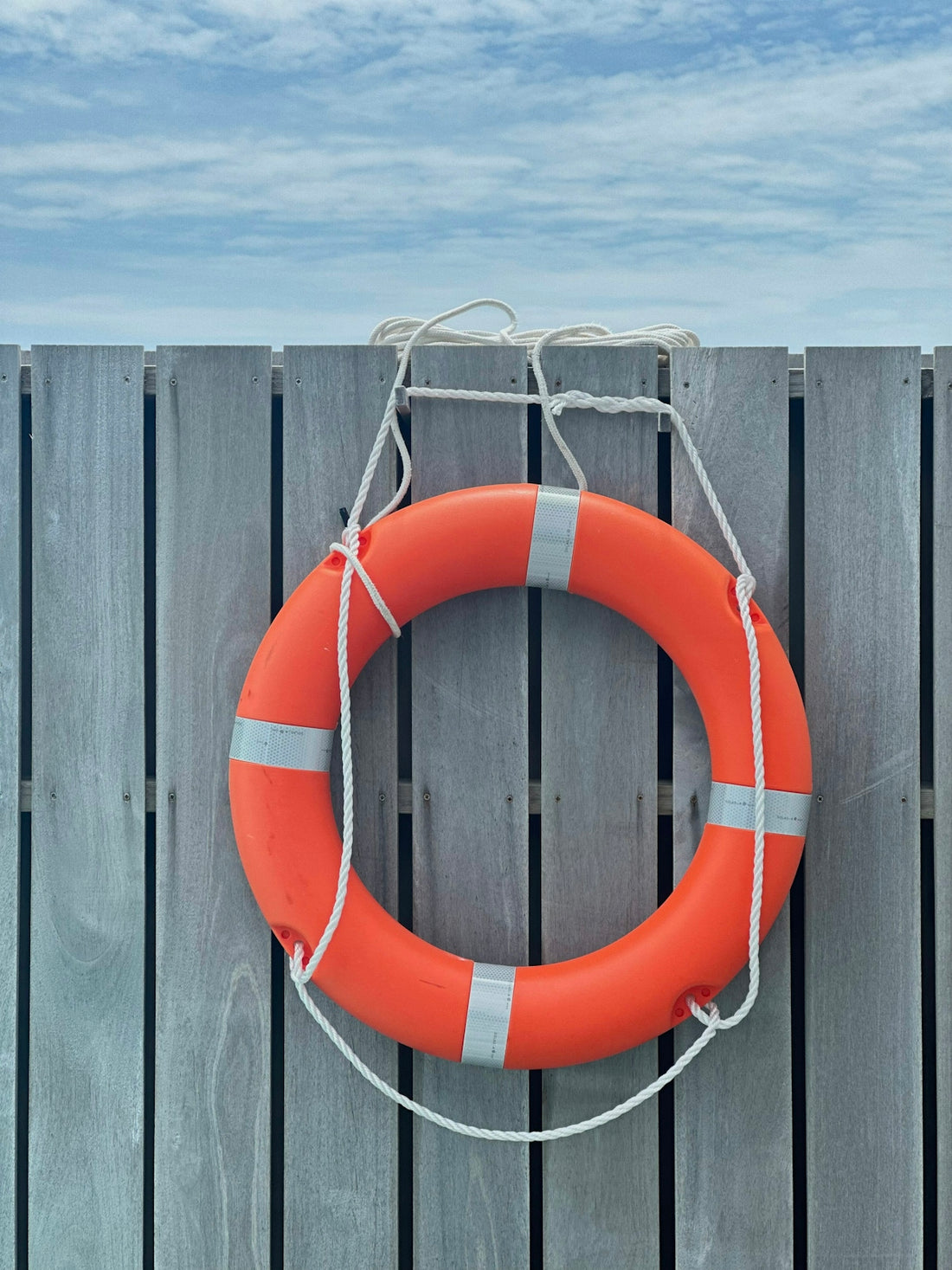 A life preserver hanging on a wooden fence