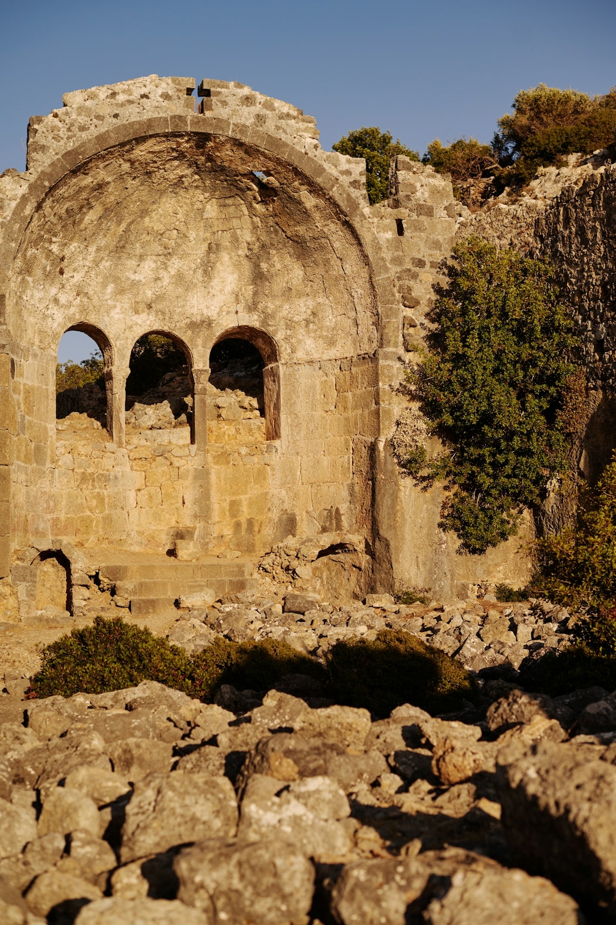 Ancient, crumbling ruins stand against a bright sky.