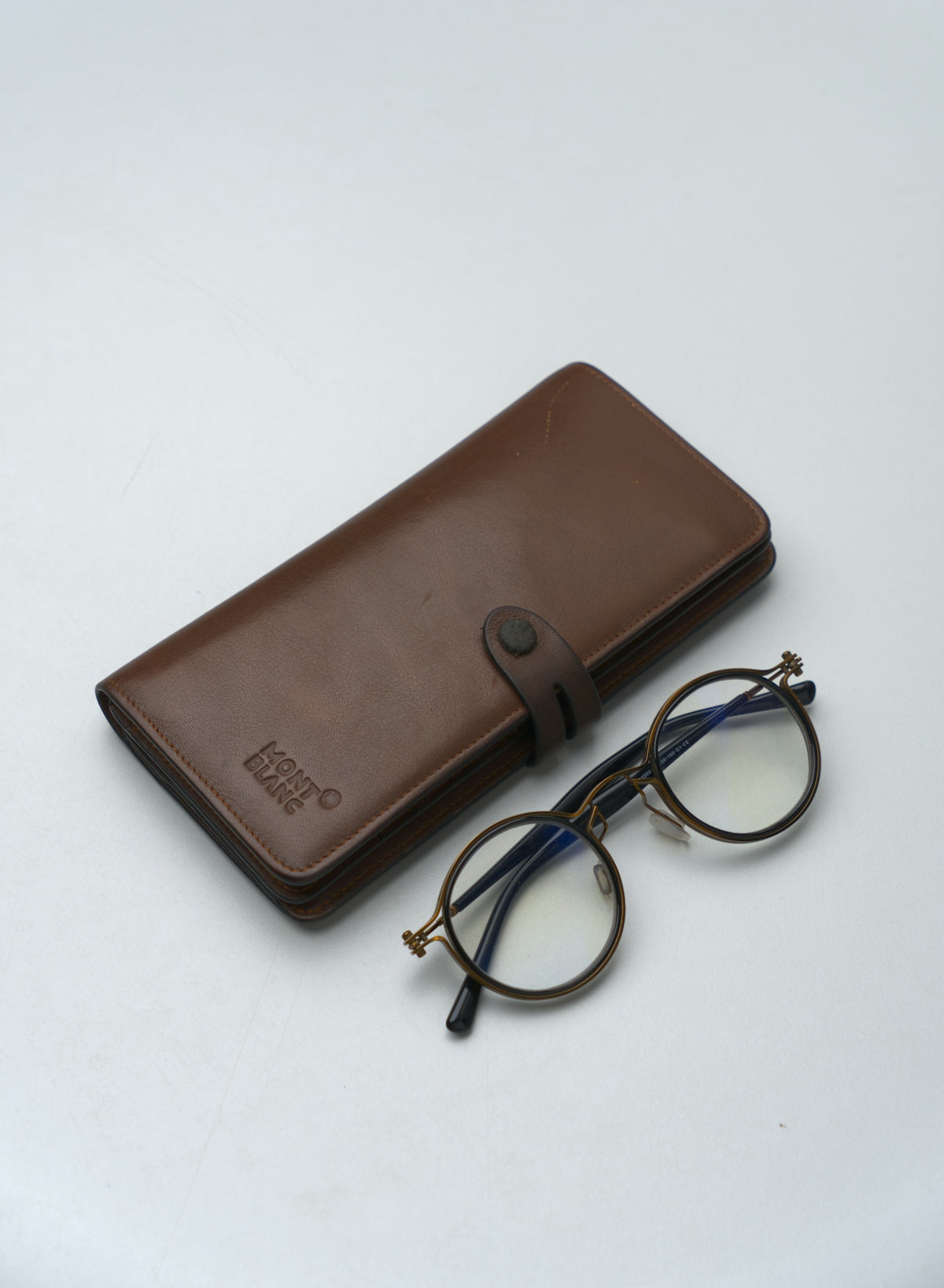 Round eyeglasses next to a brown glasses case