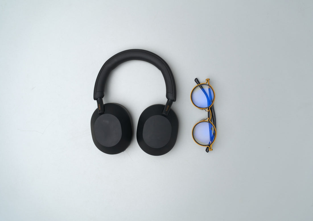 Black headphones and glasses on a light background