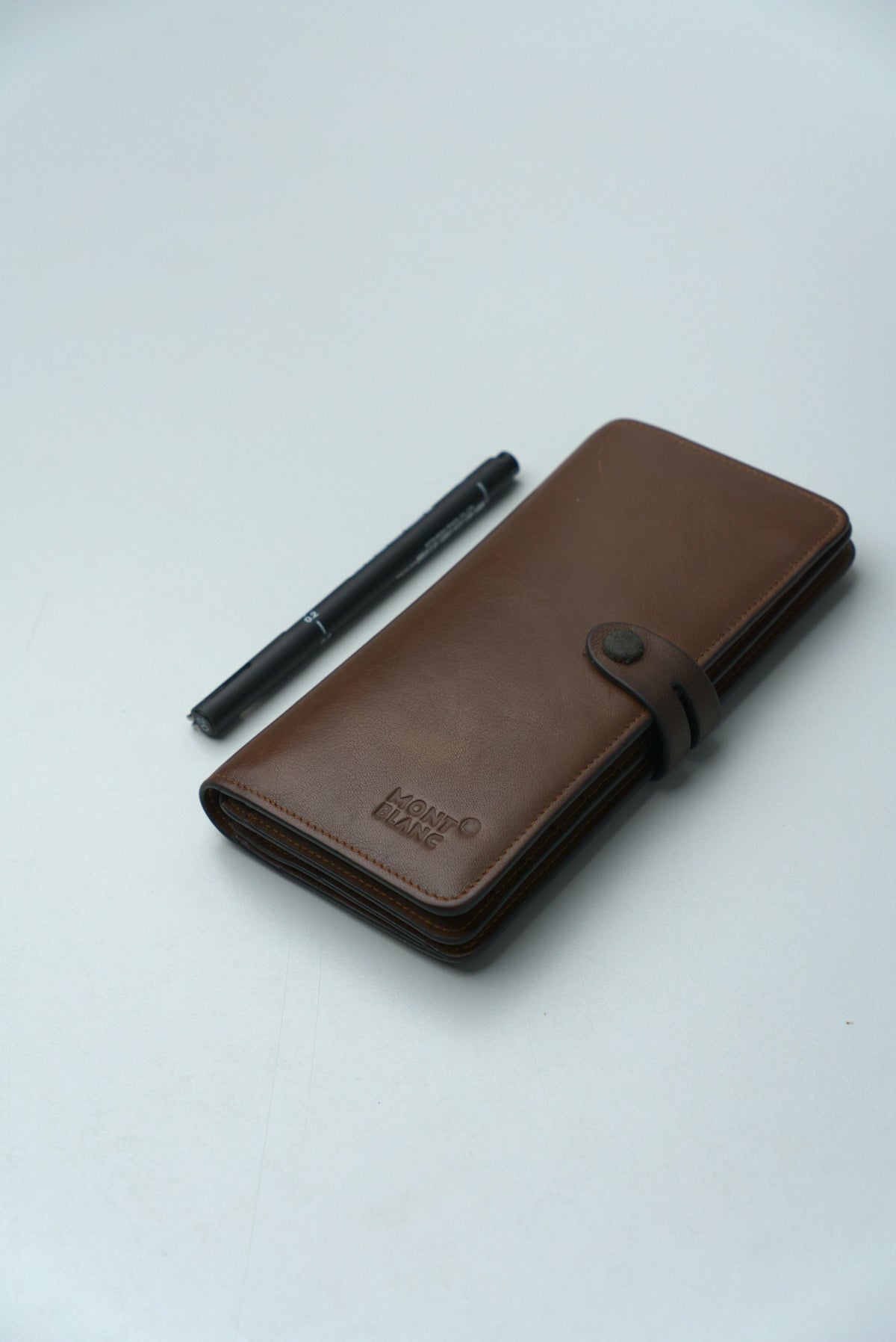 Brown leather wallet with a pen