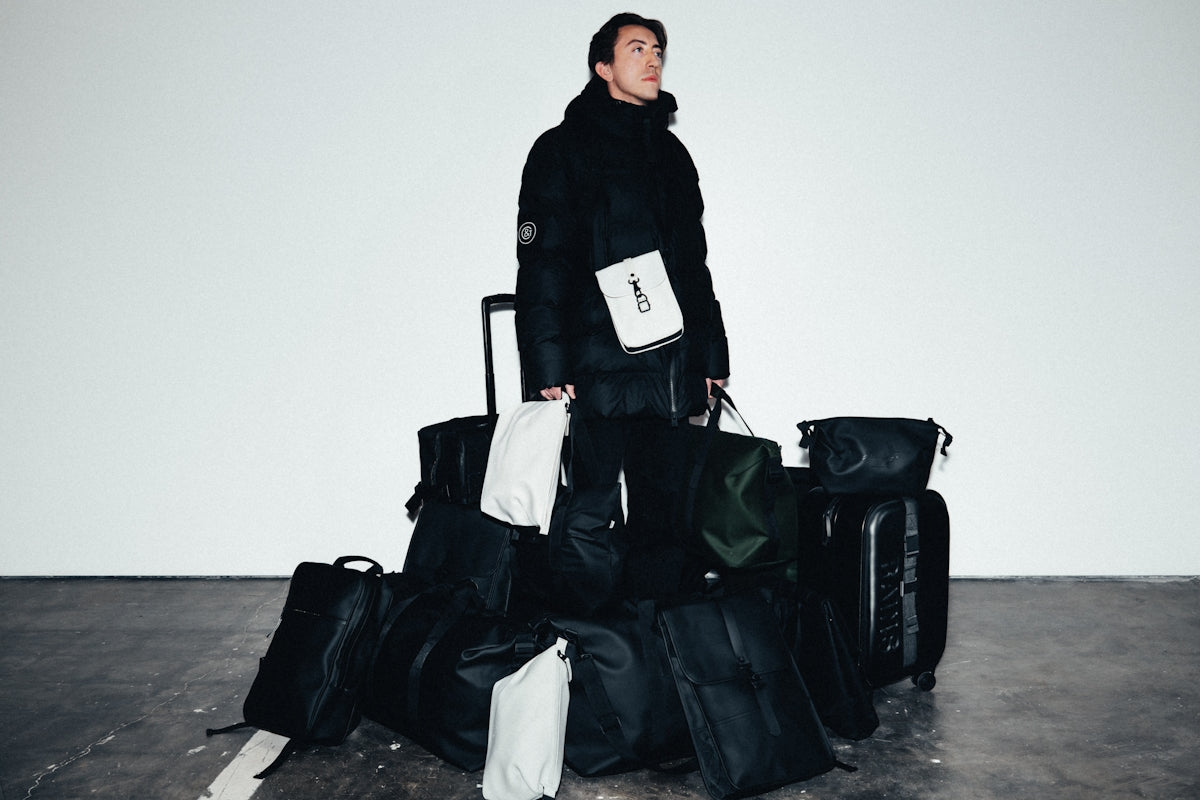 Man in winter coat surrounded by luggage