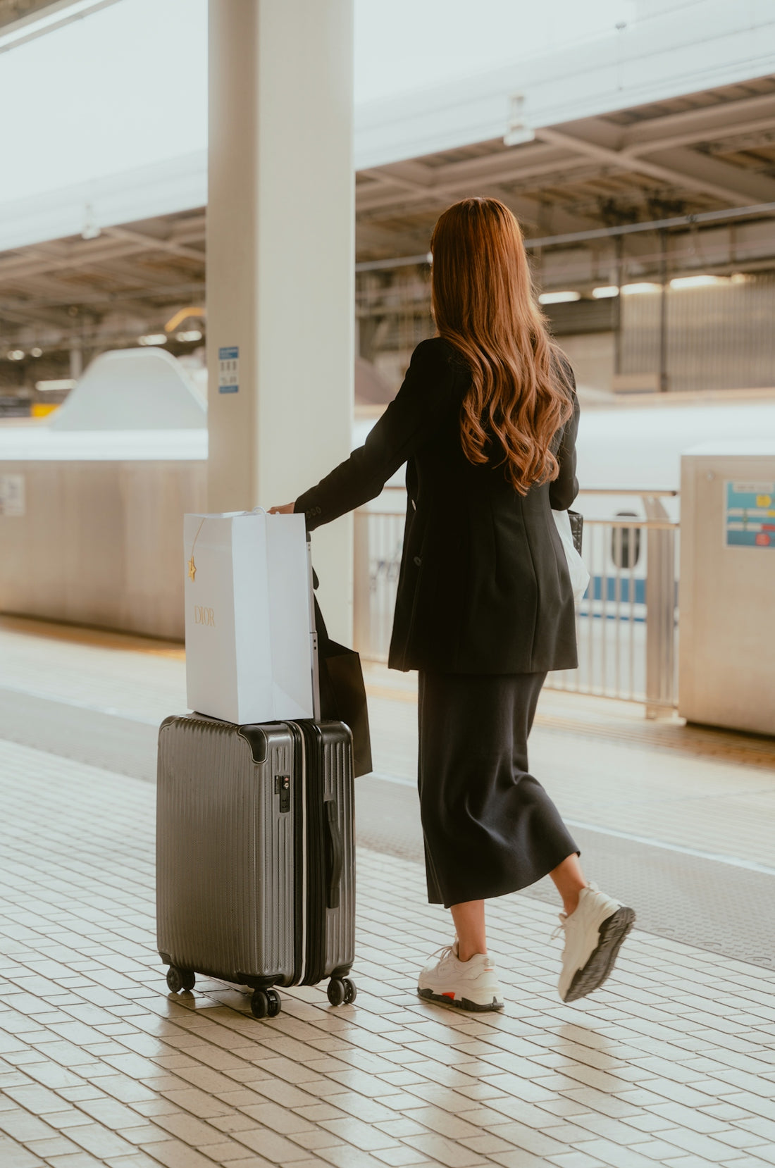 Woman with luggage at train station platform