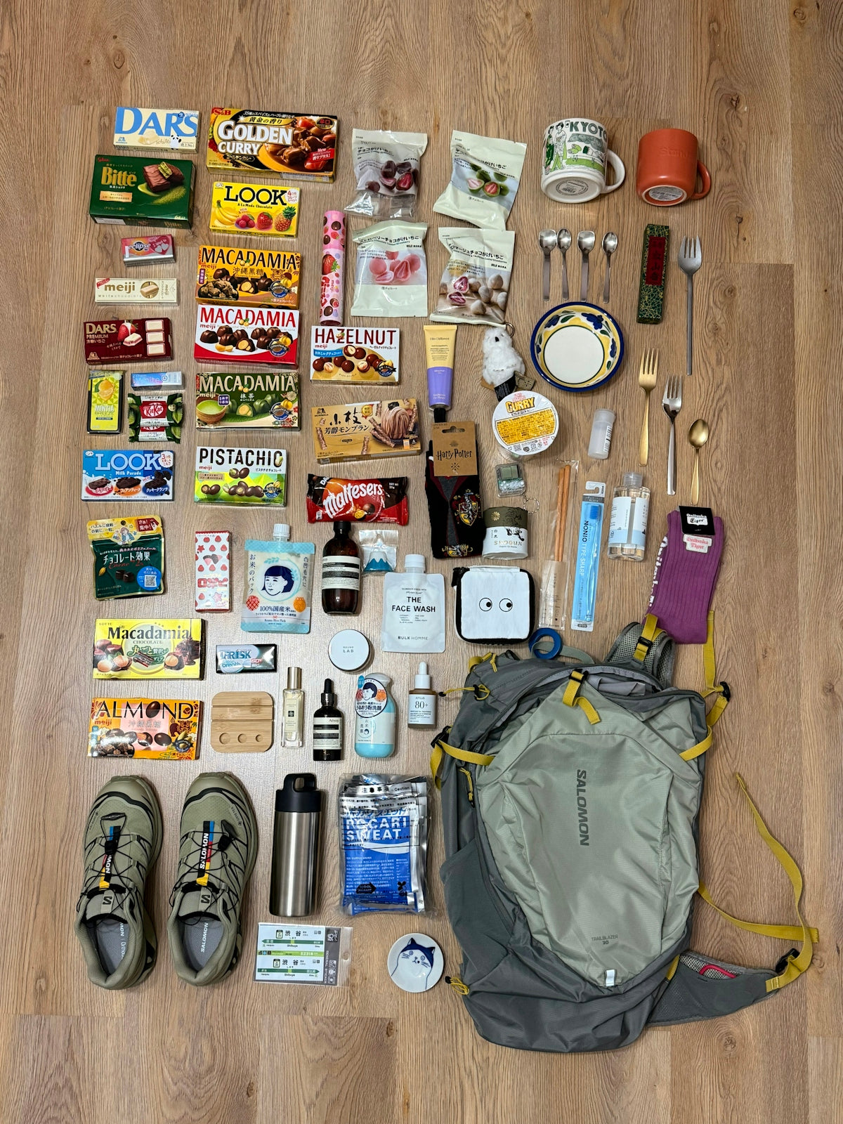 Various items laid out with a backpack and shoes