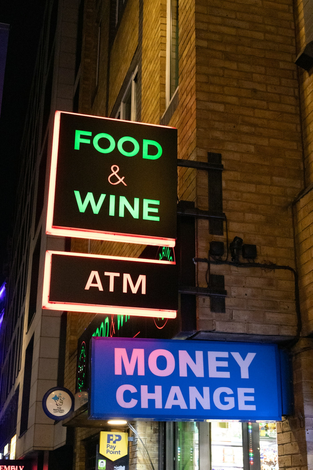 Food & wine, atm, and money change signs at night
