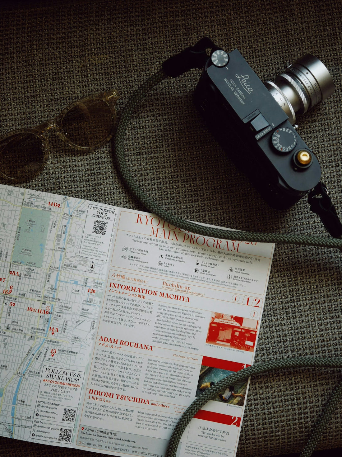 Camera, map, and sunglasses on textured surface.