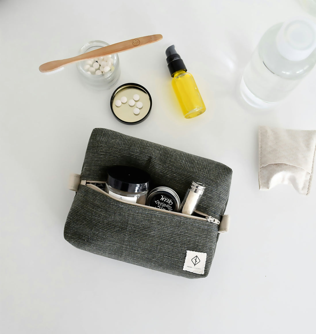 Gray toiletry bag with travel-sized cosmetics and full-sized products.
