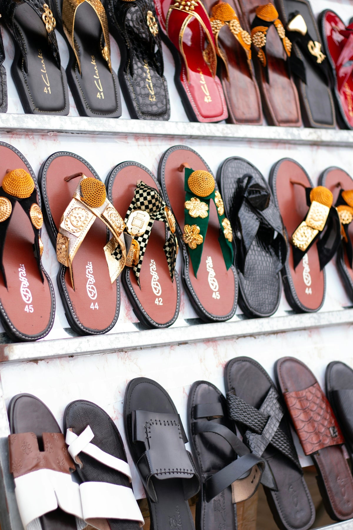 Rows of decorative sandals displayed on shelves