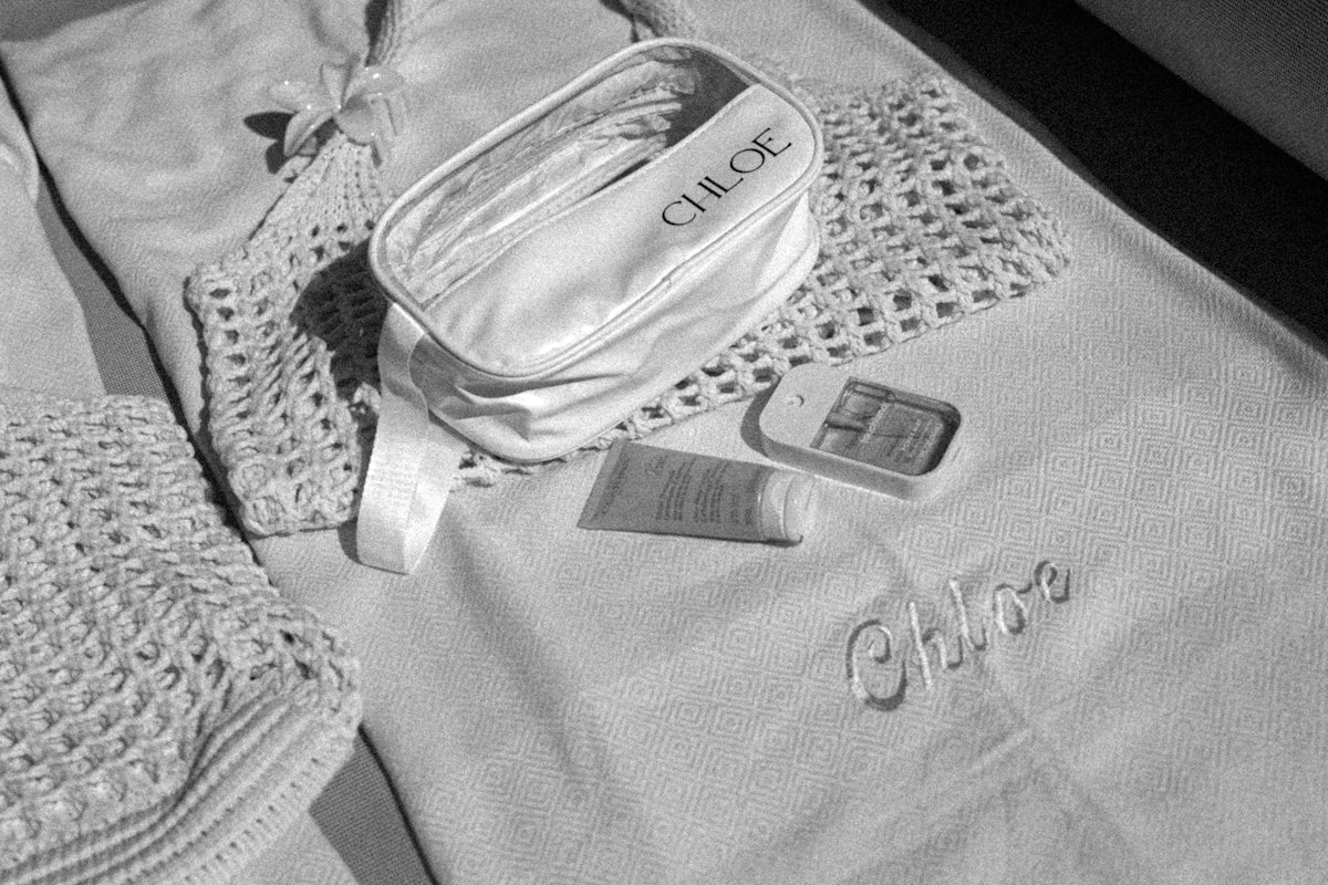 White chloe cosmetic bag with toiletries on cloth