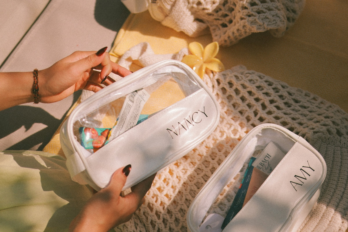 Two clear cosmetic bags with personalized names on them.