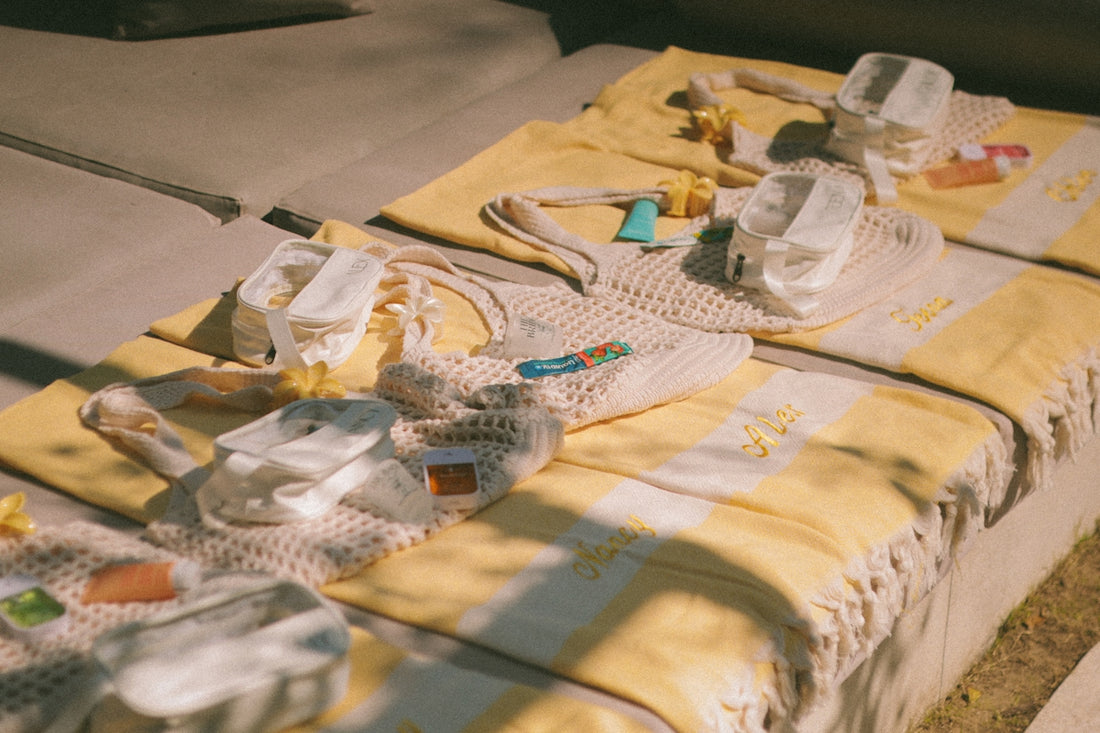 Beach towels and bags laid out on lounge chairs.