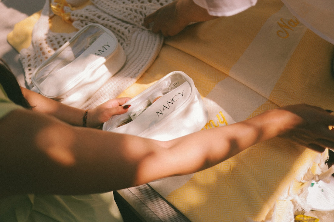 Hands arranging white fabric on a yellow tablecloth