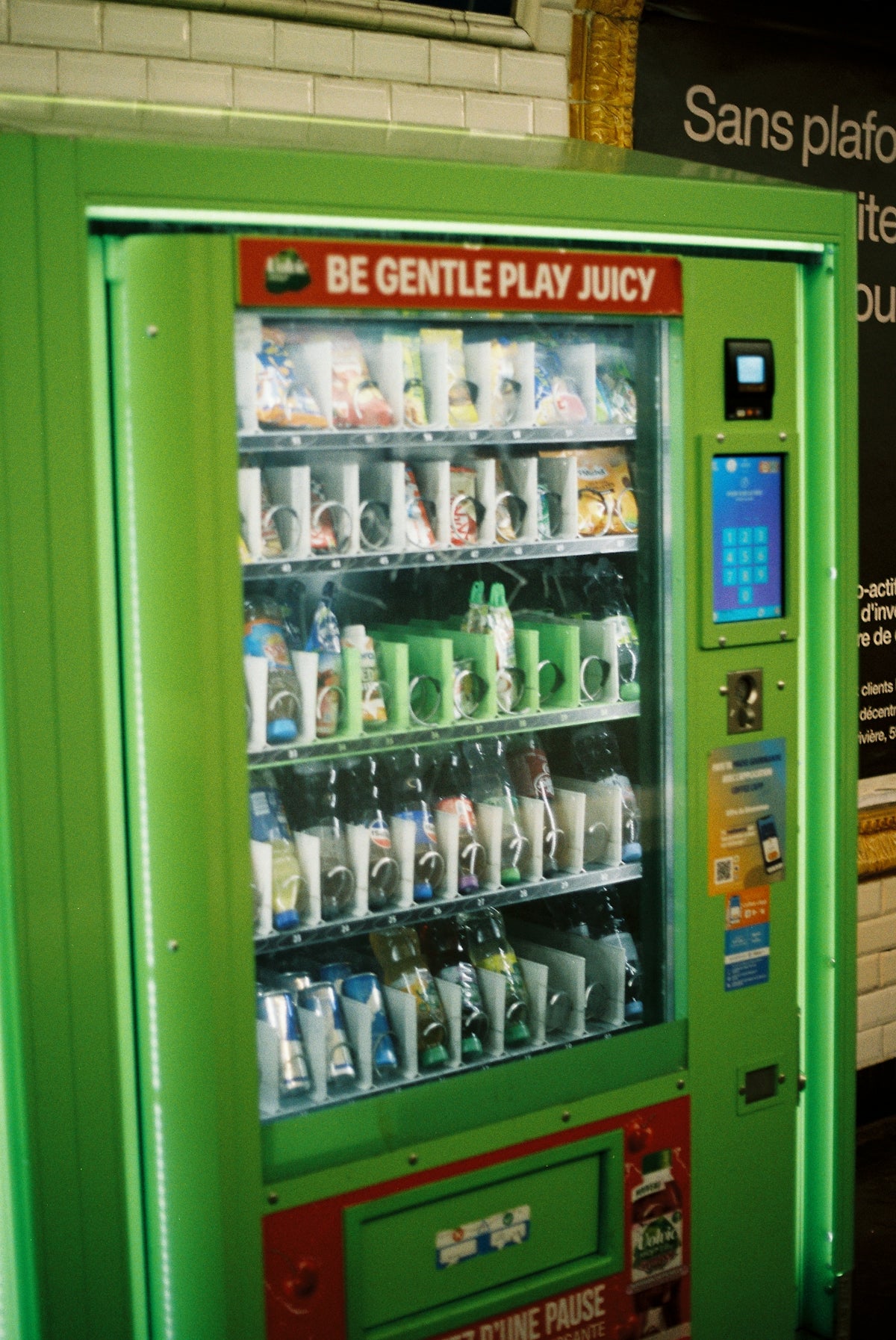 A bright green vending machine stocked with drinks.
