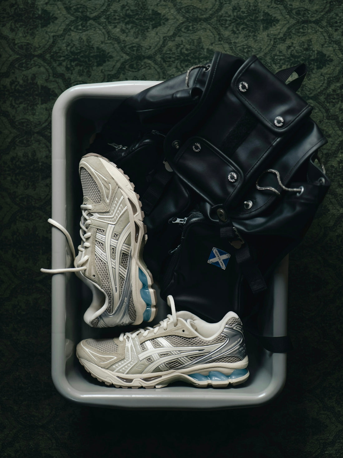 Sneakers and a black bag in a grey tray
