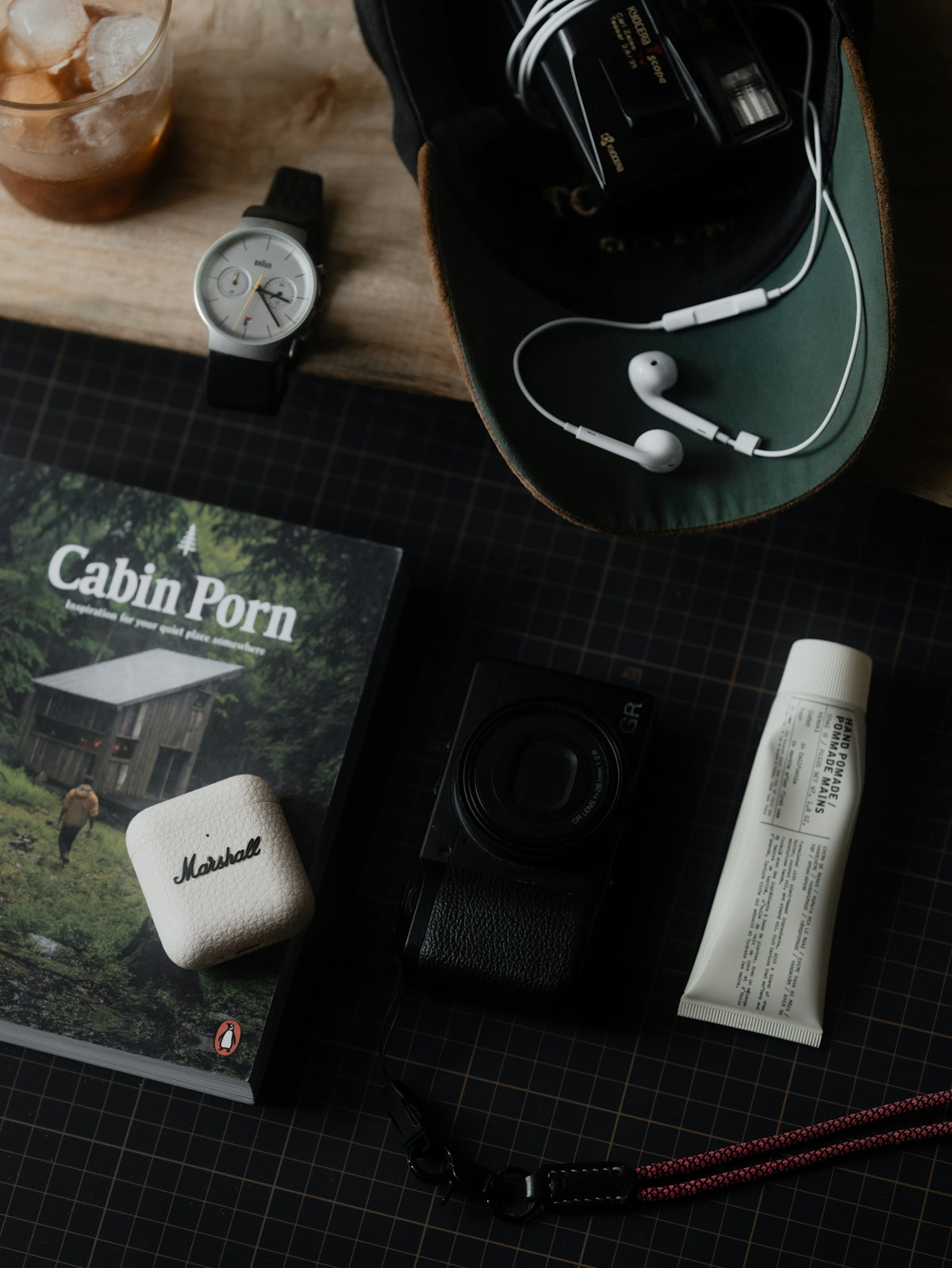 Flat lay of travel essentials including watch, camera, and headphones