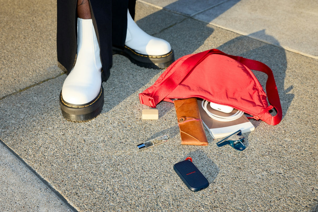 Spilled red bag contents next to white boots on concrete