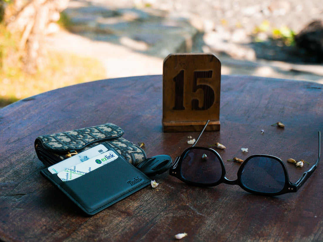 Wallet, sunglasses, and table number 15 on a wooden table