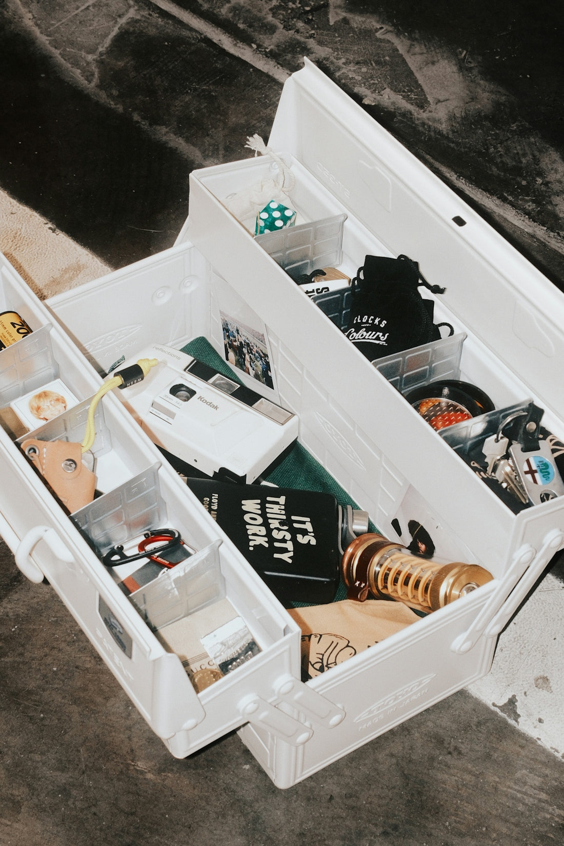 An open white toolbox filled with various tools and items.