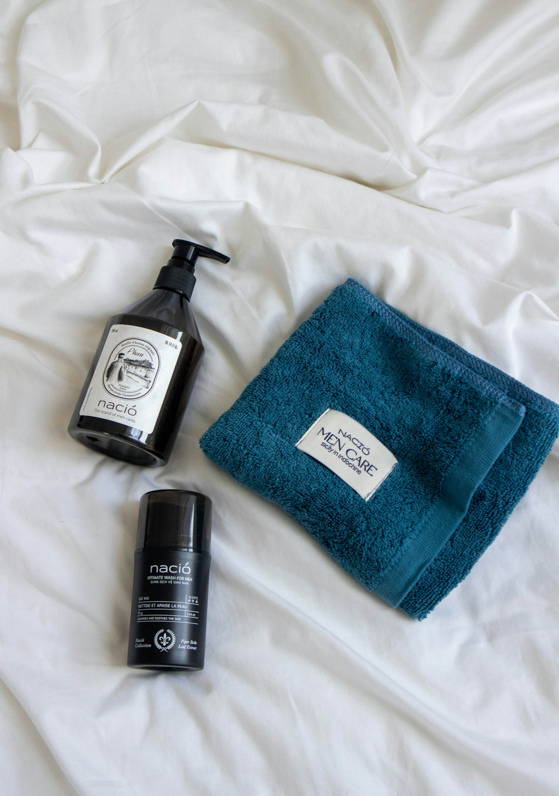 Skincare products and a blue towel on white bedding